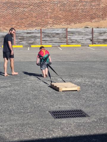 child pulling a sled during an outdoor personal training session at functional fitness eltham