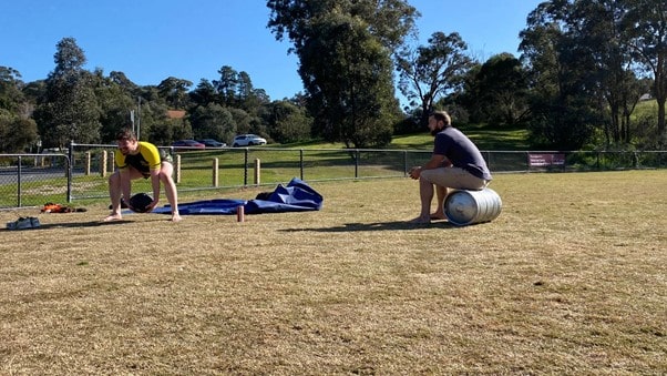 outdoor personal training session with a client lifting weights at a park in eltham