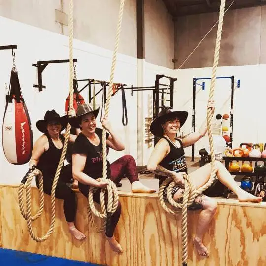 three women wearing cowboy hats smiling while sitting on ropes during a women only fitness class at functional fitness eltham showing a fun and playful atmosphere 2