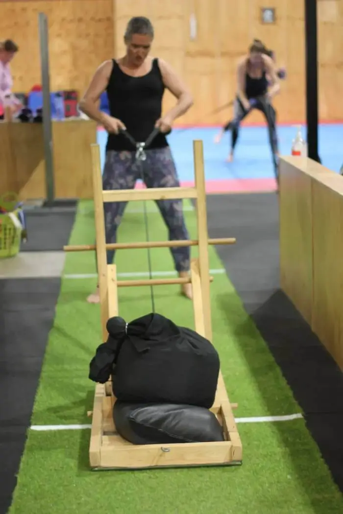 woman pulling a weighted sled during a women only fitness class at functional fitness eltham focusing on strength and endurance training