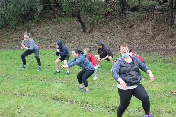 women laughing and exercising outdoors during a women only fitness class at functional fitness eltham creating a fun and engaging atmosphere