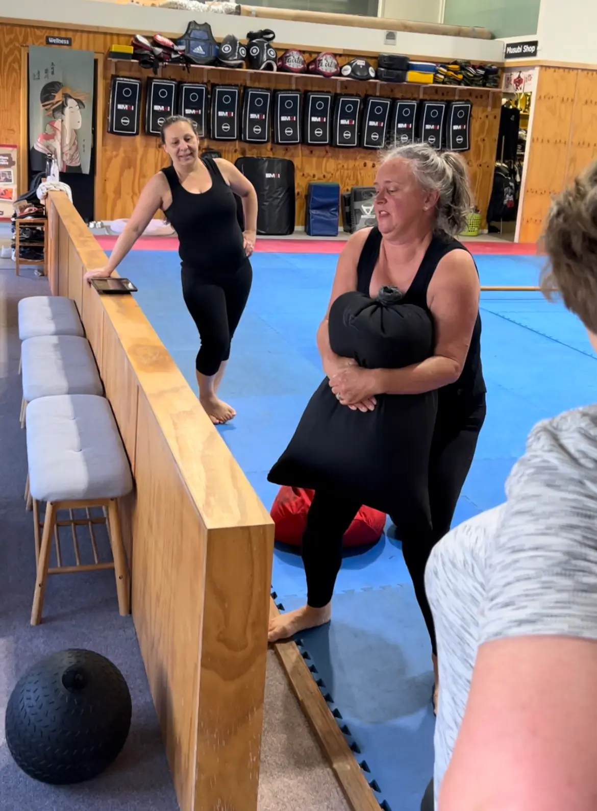 women lifting a sandbag during a women only fitness class at functional fitness eltham