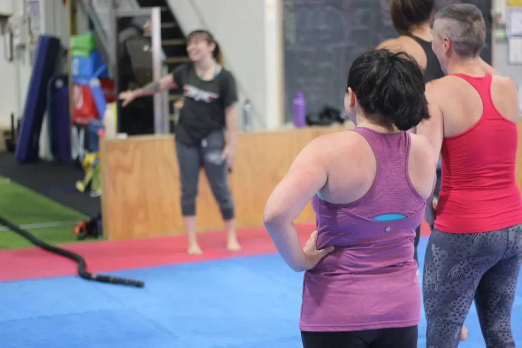 women listening to a trainer during a women only fitness class at functional fitness eltham focusing on guidance and group engagement