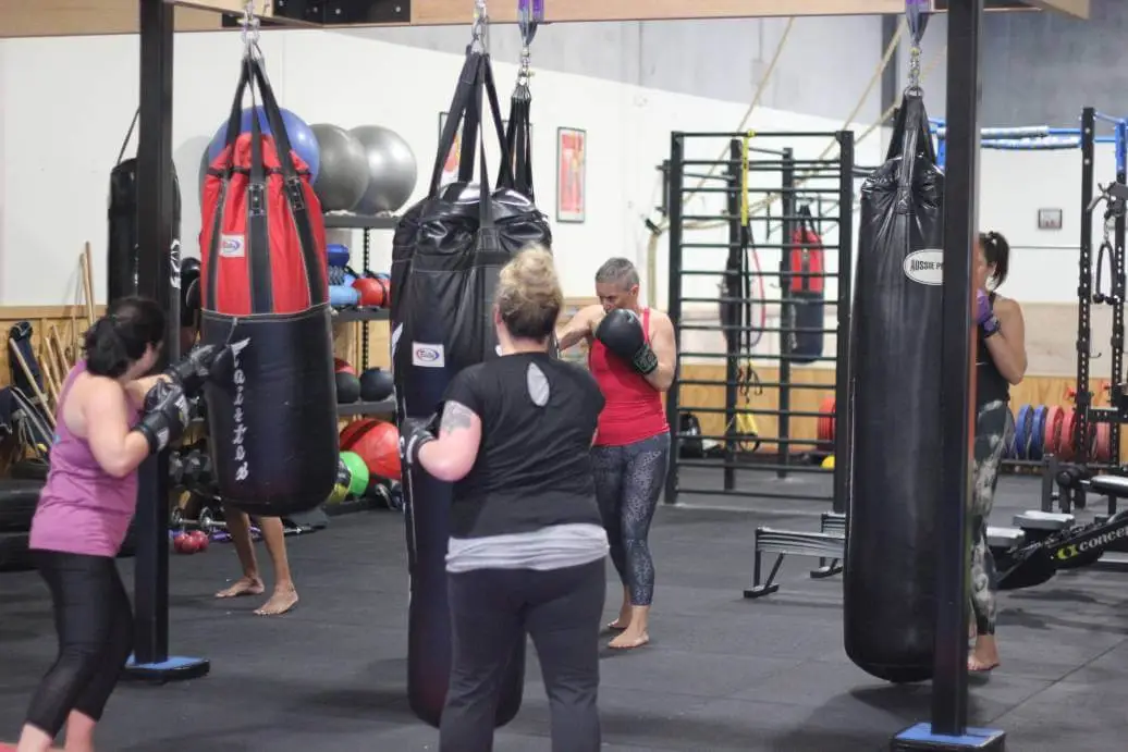 women practicing boxing drills with punching bags during a women only fitness class at functional fitness eltham focusing on strength and conditioning