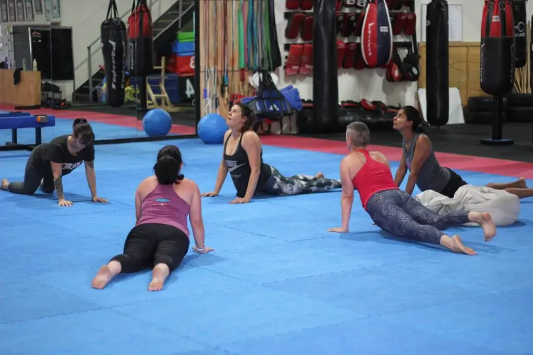 women stretching together on mats during a women only fitness class at functional fitness eltham focusing on flexibility and mobility